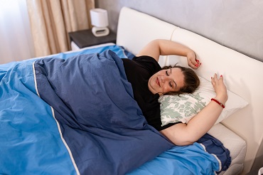 Woman waking up happy and refreshed after sleeping.