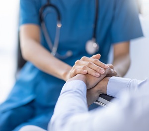 Nurse holding hand with a patient.