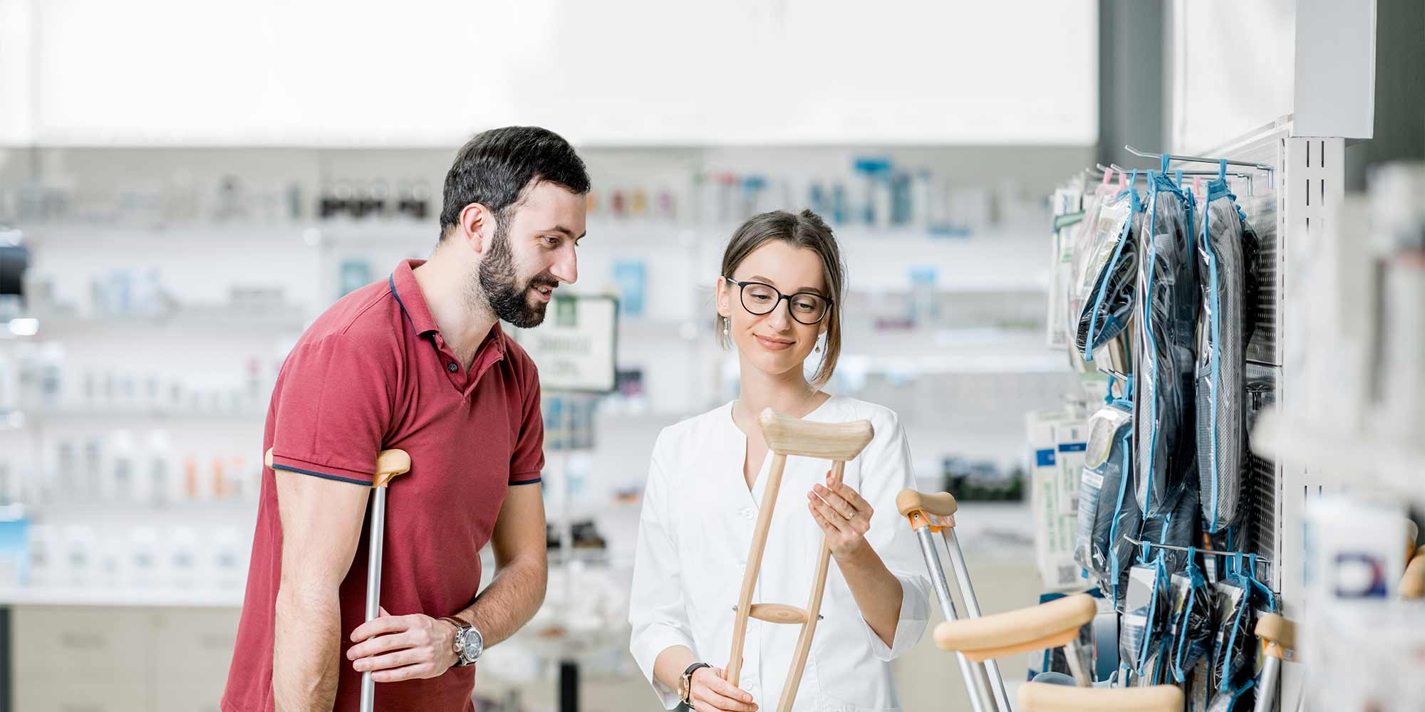 A man on crutches browses a store for medical equipment