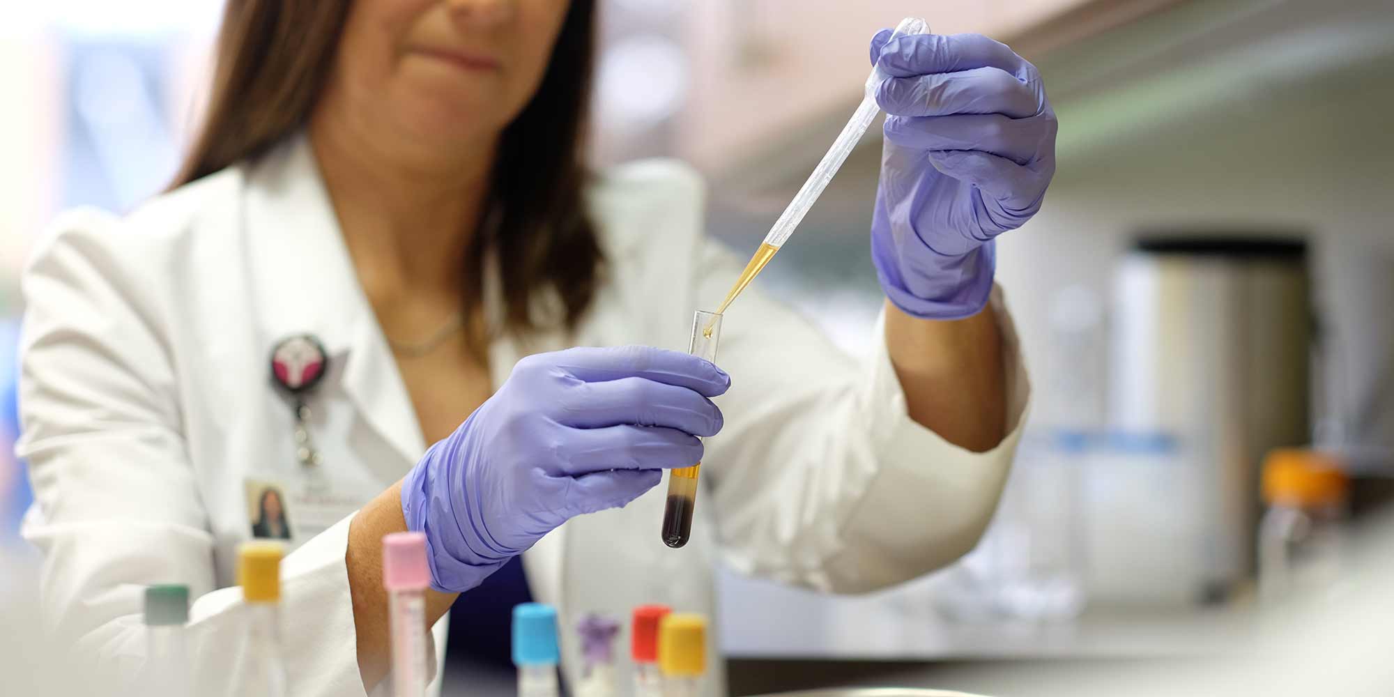 A lab worker conducts research using test tubes